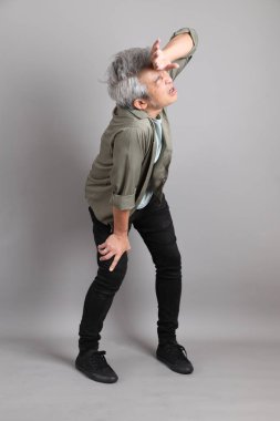 Gri arka planda duran 40 'lı yılların Asyalı, şık, sıradan elbiseli adamı.. 