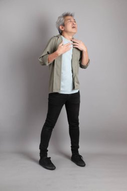 Gri arka planda duran 40 'lı yılların Asyalı, şık, sıradan elbiseli adamı.. 