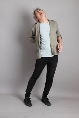 Gri arka planda duran 40 'lı yılların Asyalı, şık, sıradan elbiseli adamı.. 