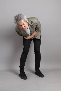 Gri arka planda duran 40 'lı yılların Asyalı, şık, sıradan elbiseli adamı.. 