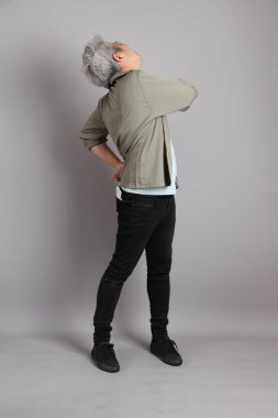 Gri arka planda duran 40 'lı yılların Asyalı, şık, sıradan elbiseli adamı.. 