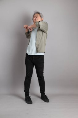 Gri arka planda duran 40 'lı yılların Asyalı, şık, sıradan elbiseli adamı.. 