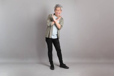 Gri arka planda duran 40 'lı yılların Asyalı, şık, sıradan elbiseli adamı.. 