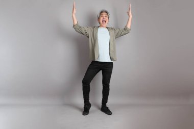 Gri arka planda duran 40 'lı yılların Asyalı, şık, sıradan elbiseli adamı.. 