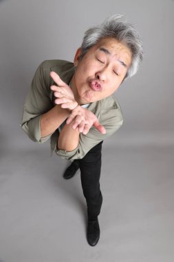 Gri arka planda duran 40 'lı yılların Asyalı, şık, sıradan elbiseli adamı.. 