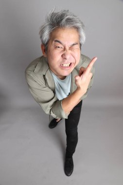 Gri arka planda duran 40 'lı yılların Asyalı, şık, sıradan elbiseli adamı.. 