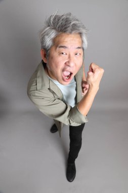 Gri arka planda duran 40 'lı yılların Asyalı, şık, sıradan elbiseli adamı.. 