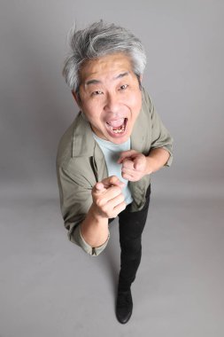 Gri arka planda duran 40 'lı yılların Asyalı, şık, sıradan elbiseli adamı.. 