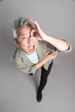 Gri arka planda duran 40 'lı yılların Asyalı, şık, sıradan elbiseli adamı.. 