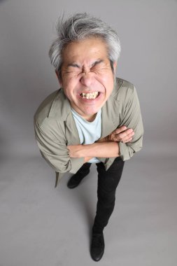 Gri arka planda duran 40 'lı yılların Asyalı, şık, sıradan elbiseli adamı.. 