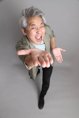 Gri arka planda duran 40 'lı yılların Asyalı, şık, sıradan elbiseli adamı.. 