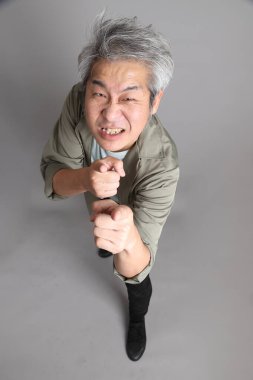 Gri arka planda duran 40 'lı yılların Asyalı, şık, sıradan elbiseli adamı.. 