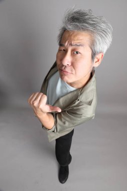 Gri arka planda duran 40 'lı yılların Asyalı, şık, sıradan elbiseli adamı.. 