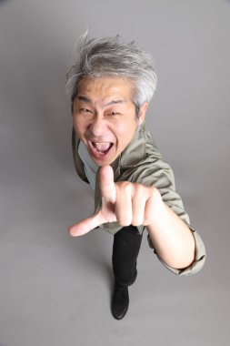 Gri arka planda duran 40 'lı yılların Asyalı, şık, sıradan elbiseli adamı.. 