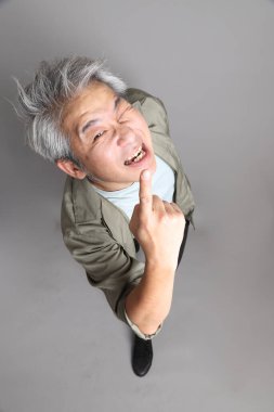 Gri arka planda duran 40 'lı yılların Asyalı, şık, sıradan elbiseli adamı.. 