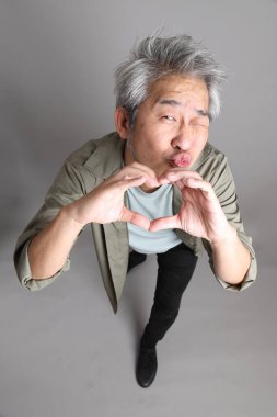 Gri arka planda duran 40 'lı yılların Asyalı, şık, sıradan elbiseli adamı.. 