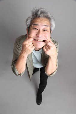 Gri arka planda duran 40 'lı yılların Asyalı, şık, sıradan elbiseli adamı.. 