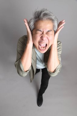 Gri arka planda duran 40 'lı yılların Asyalı, şık, sıradan elbiseli adamı.. 