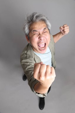 Gri arka planda duran 40 'lı yılların Asyalı, şık, sıradan elbiseli adamı.. 