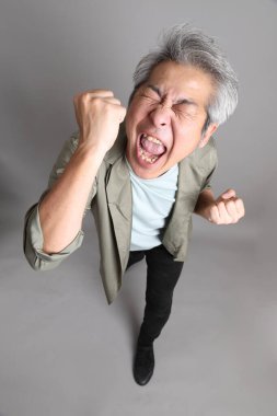 Gri arka planda duran 40 'lı yılların Asyalı, şık, sıradan elbiseli adamı.. 