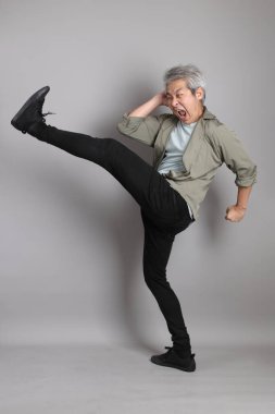 Gri arka planda duran 40 'lı yılların Asyalı, şık, sıradan elbiseli adamı.. 