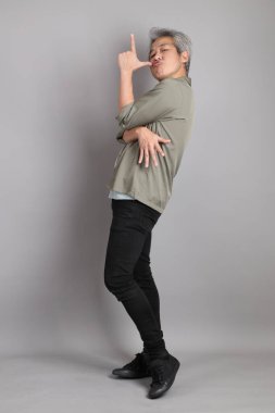 Gri arka planda duran 40 'lı yılların Asyalı, şık, sıradan elbiseli adamı.. 