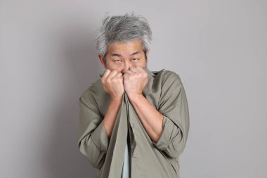 Gri arka planda duran 40 'lı yılların Asyalı, şık, sıradan elbiseli adamı.. 