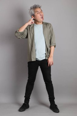 Gri arka planda duran 40 'lı yılların Asyalı, şık, sıradan elbiseli adamı.. 