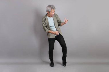 Gri arka planda duran 40 'lı yılların Asyalı, şık, sıradan elbiseli adamı.. 