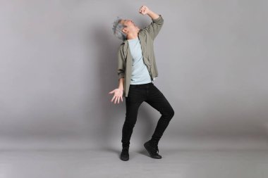 Gri arka planda duran 40 'lı yılların Asyalı, şık, sıradan elbiseli adamı.. 