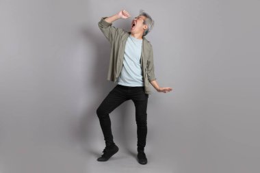 Gri arka planda duran 40 'lı yılların Asyalı, şık, sıradan elbiseli adamı.. 