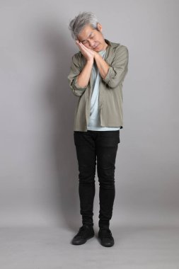 Gri arka planda duran 40 'lı yılların Asyalı, şık, sıradan elbiseli adamı.. 