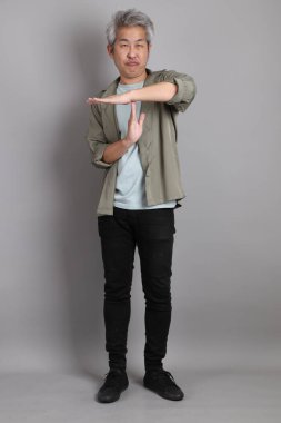 Gri arka planda duran 40 'lı yılların Asyalı, şık, sıradan elbiseli adamı.. 