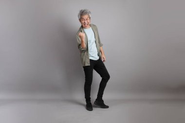 Gri arka planda duran 40 'lı yılların Asyalı, şık, sıradan elbiseli adamı.. 