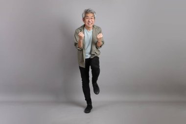 Gri arka planda duran 40 'lı yılların Asyalı, şık, sıradan elbiseli adamı.. 