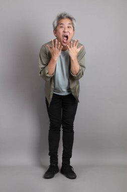 Gri arka planda duran 40 'lı yılların Asyalı, şık, sıradan elbiseli adamı.. 