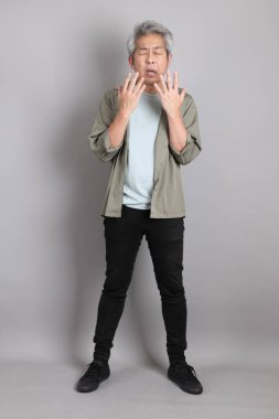 Gri arka planda duran 40 'lı yılların Asyalı, şık, sıradan elbiseli adamı.. 