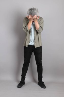 Gri arka planda duran 40 'lı yılların Asyalı, şık, sıradan elbiseli adamı.. 