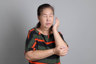 Gri arka planda günlük giysileri olan 70 'lerin son sınıf Çinli kadını..