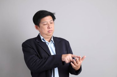 Resmi giyinmiş Asyalı iş adamı. Gri arkaplanda sayma numarası var..