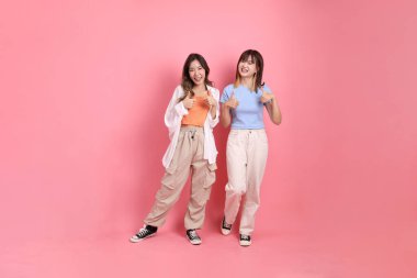 Yetişkin genç arkadaşlar, 20 'li yaşlarda Doğu Asyalı kadınlar pembe arka planda.. 