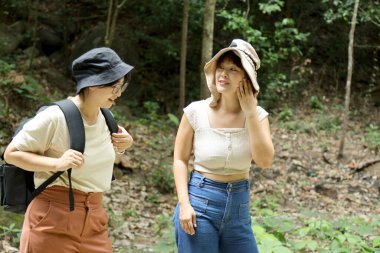 İki Asyalı kardeş yaz mevsiminde gündüz vakti ormanda birlikte vakit geçiriyorlar..