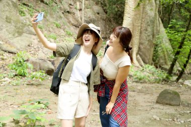 İki Asyalı arkadaş yaz mevsiminde gündüz vakti ormanda birlikte vakit geçiriyorlar..