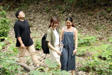 Üç Asyalı arkadaş yaz mevsiminde gündüz vakti ormanda birlikte vakit geçiriyorlar..