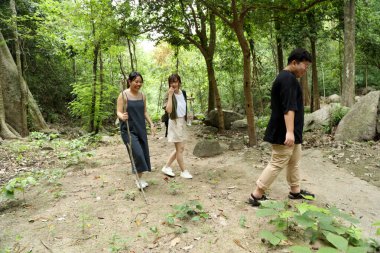 Üç Asyalı arkadaş yaz mevsiminde gündüz vakti ormanda birlikte vakit geçiriyorlar..