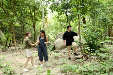 Üç Asyalı arkadaş yaz mevsiminde gündüz vakti ormanda birlikte vakit geçiriyorlar..