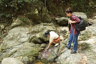 İki Asyalı kardeş yaz mevsiminde gündüz vakti gölün kenarında birlikte vakit geçiriyorlar..
