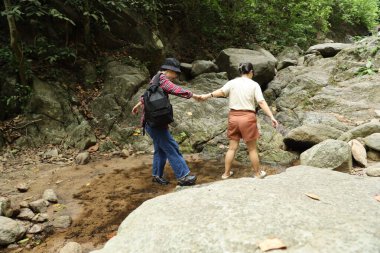 İki Asyalı kardeş yaz mevsiminde gündüz vakti gölün kenarında birlikte vakit geçiriyorlar..