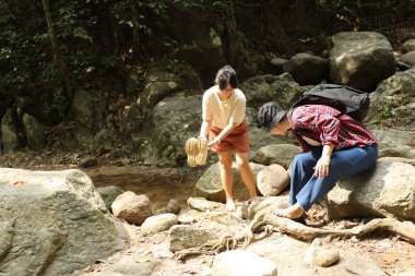 İki Asyalı kardeş yaz mevsiminde gündüz vakti gölün kenarında birlikte vakit geçiriyorlar..
