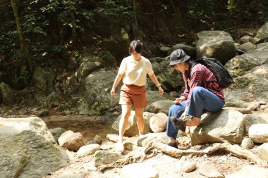 İki Asyalı kardeş yaz mevsiminde gündüz vakti gölün kenarında birlikte vakit geçiriyorlar..
